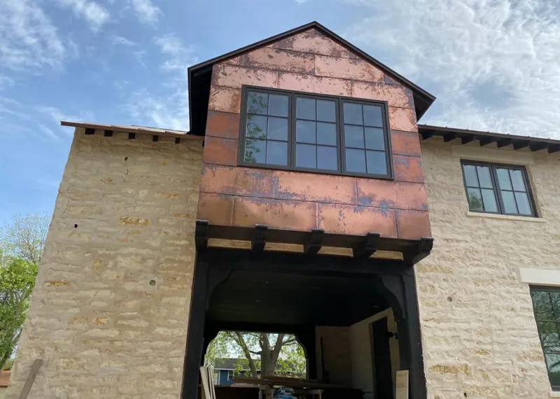 Copper metal panel facade on a stone building for Roof Repair in Parkland